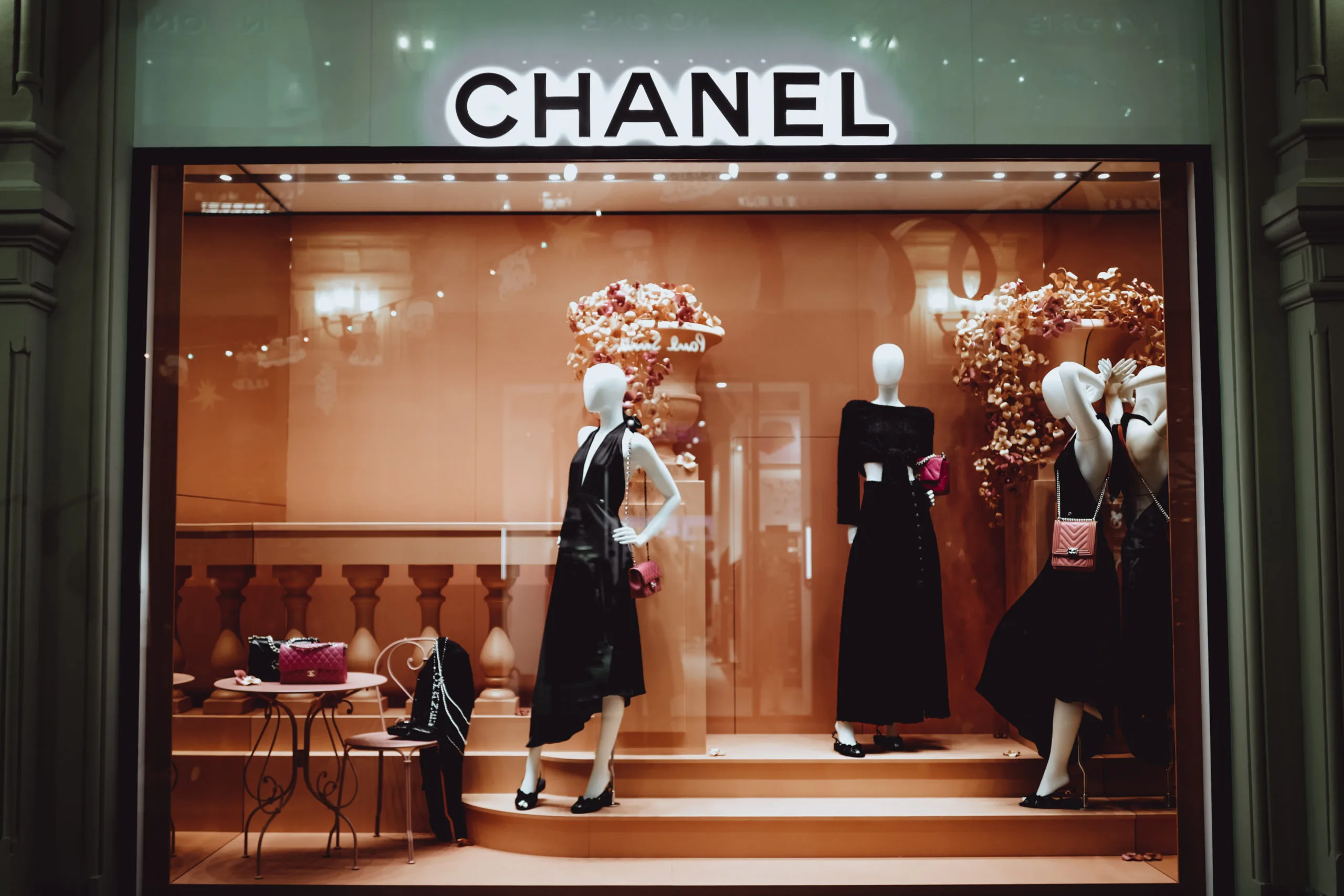 Female stylish mannequins in a shop window with Chanel bags. Chanel is a high fashion brand founded by Coco Chanel in 1909